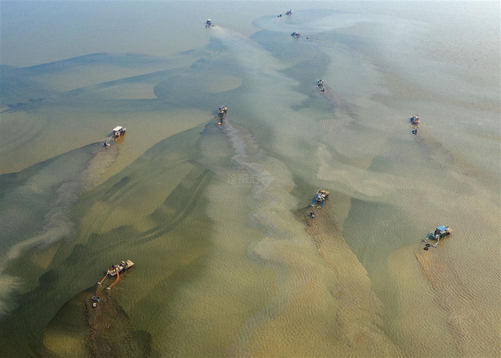 挖蛤的机械在海面上绣出了一幅巨大的油画