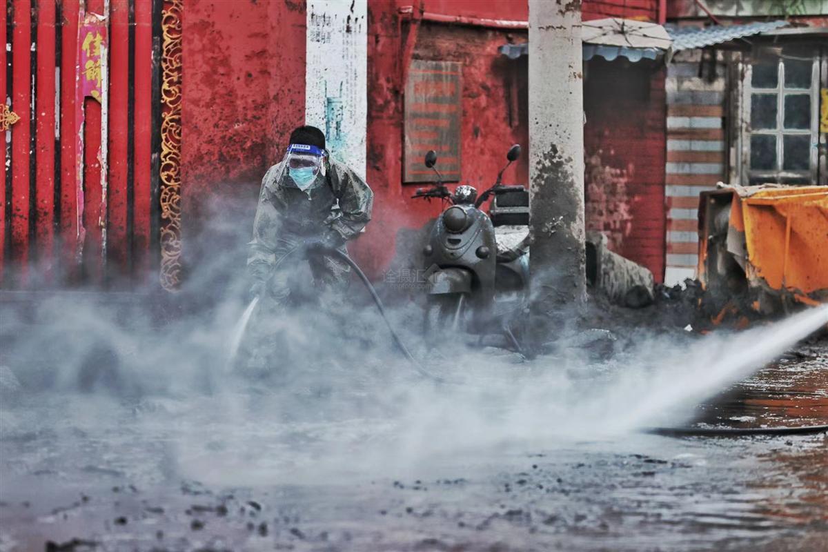 北京卫戍区防化团官兵正在对一处断电冷库外围进行洗消作业——付丁 摄